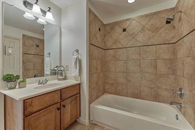 a bathroom with a sink vanity tub and shower