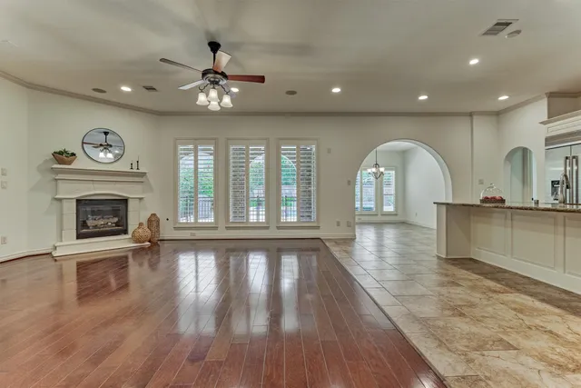 a view of an empty room with a fireplace and wooden floor