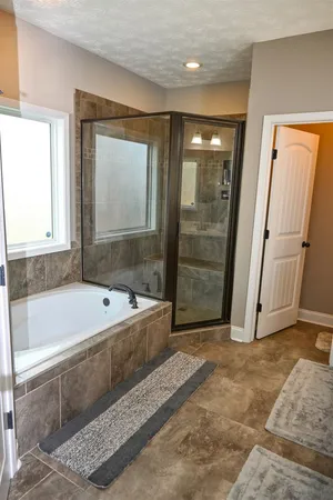 a bathroom with a large tub shower and sink