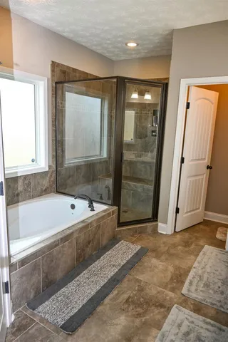 a bathroom with a large tub shower and sink