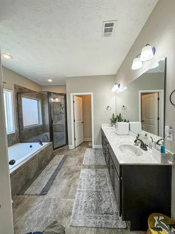 a large bathroom with a double vanity sink a large mirror and a bathtub