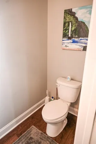 a white toilet sitting next to a small window