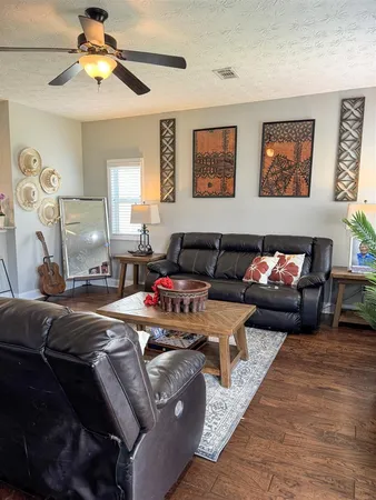 a living room with furniture and a ceiling fan
