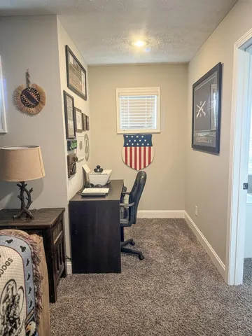 a view of a workspace with furniture and a window