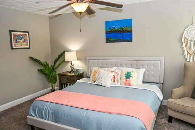 a bedroom with a bed a lamp and a chandelier