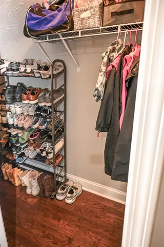 a view of walk in closet with clothes and shoes