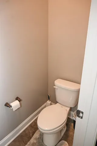 a white toilet sitting next to a white wall