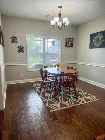 a view of a dining room with furniture wooden floor and chandelier
