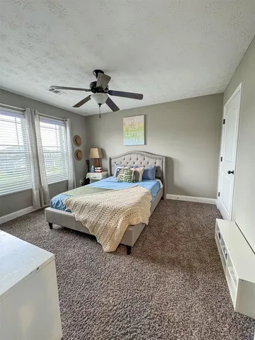 a spacious bedroom with a bed and a chandelier
