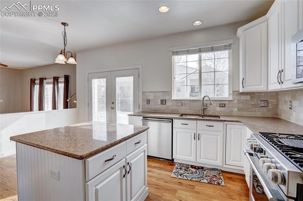 409 Avocet Loop Colorado Springs, CO 80921 - Photo 11 of 34 a kitchen that has a sink a stove a center island and a window