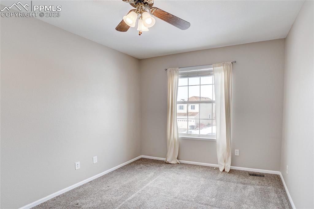 409 Avocet Loop Colorado Springs, CO 80921 - Photo 22 of 34 an empty room with windows and chandelier fan