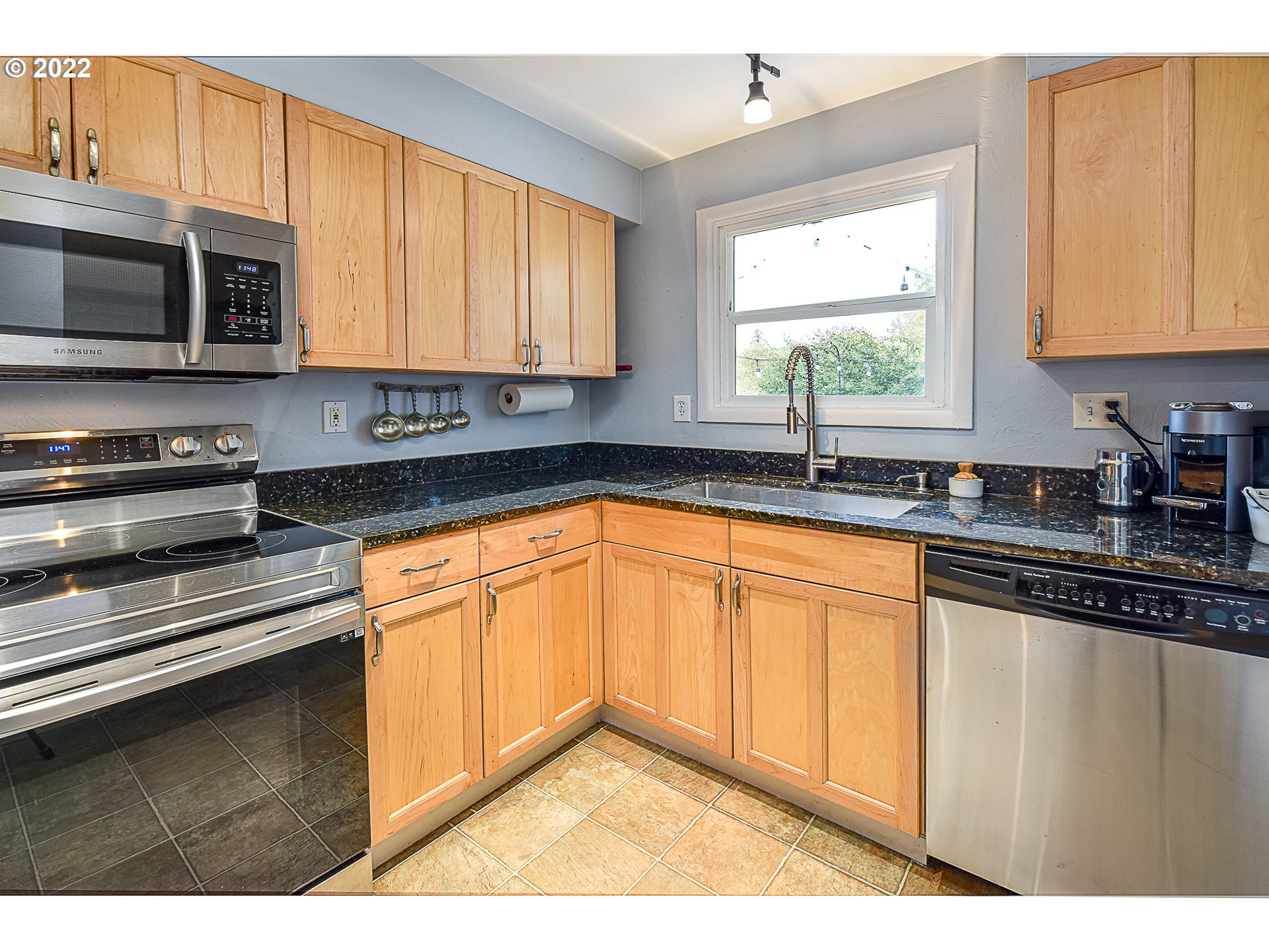 3241 Pheasant Boulevard Springfield, OR 97477 - Photo 11 of 28 a kitchen with stainless steel appliances granite countertop a sink stove and microwave