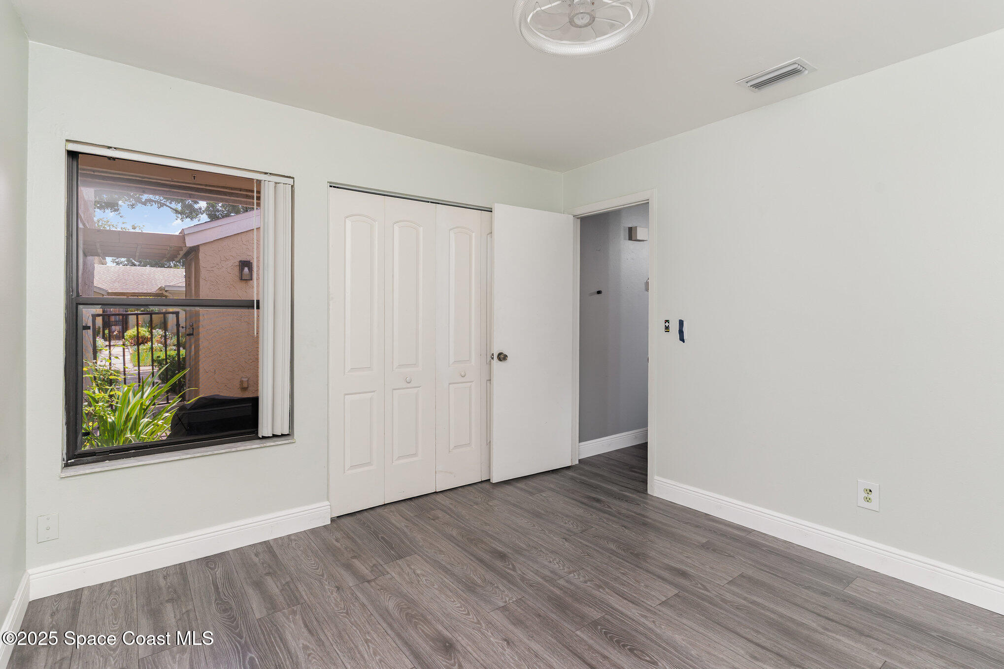 1040 Abada Court Northeast, Unit 109 Palm Bay, FL 32905 - Photo 14 of 25 a view of an empty room with window and wooden floor