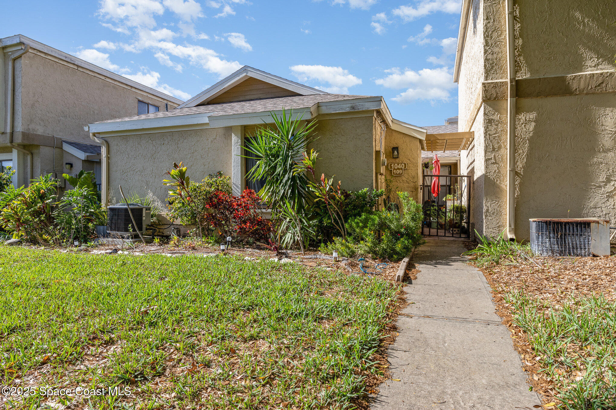 1040 Abada Court Northeast, Unit 109 Palm Bay, FL 32905 - Photo 6 of 25 a front view of a house with a yard