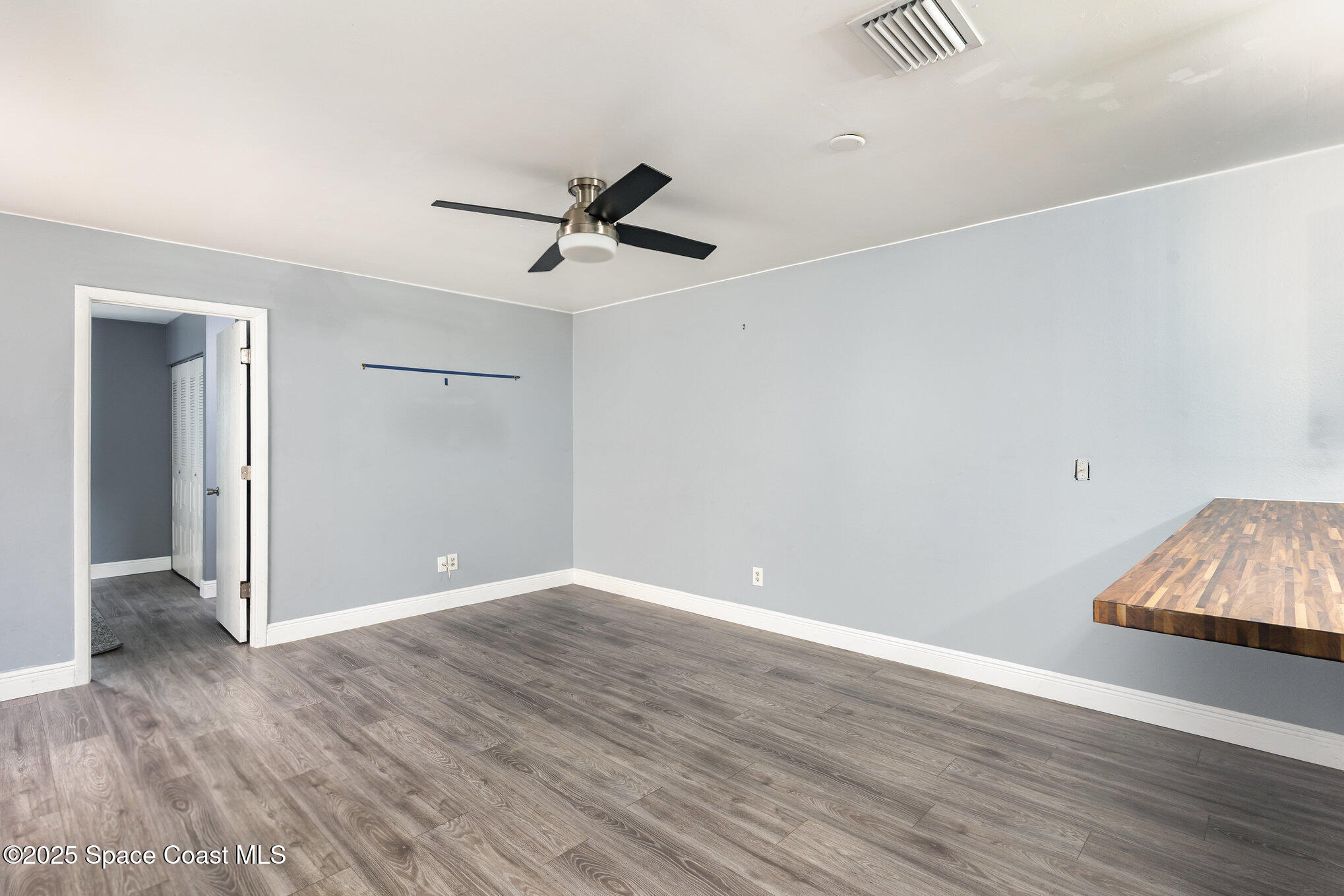 1040 Abada Court Northeast, Unit 109 Palm Bay, FL 32905 - Photo 7 of 25 an empty room with wooden floor and ceiling fan