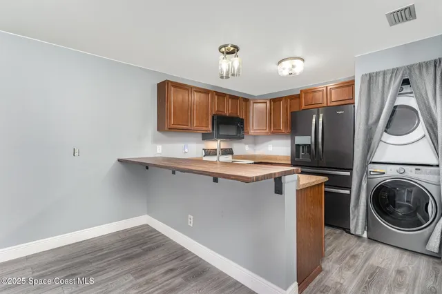 a kitchen with stainless steel appliances granite countertop a table chairs and a refrigerator