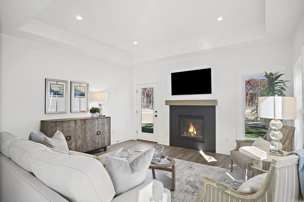 25 Salisbury Hill Boulevard, Unit 56 Worcester, MA 01609 - Photo 13 of 41 a living room with furniture a fireplace and a flat screen tv