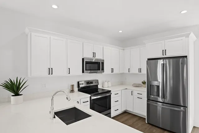 a kitchen with white cabinets and stainless steel appliances