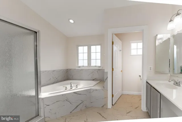 a bathroom with a tub sink and mirror