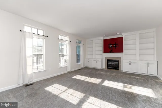 a view of an empty room with a fireplace and a window