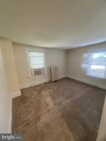 an empty room with a fireplace and windows
