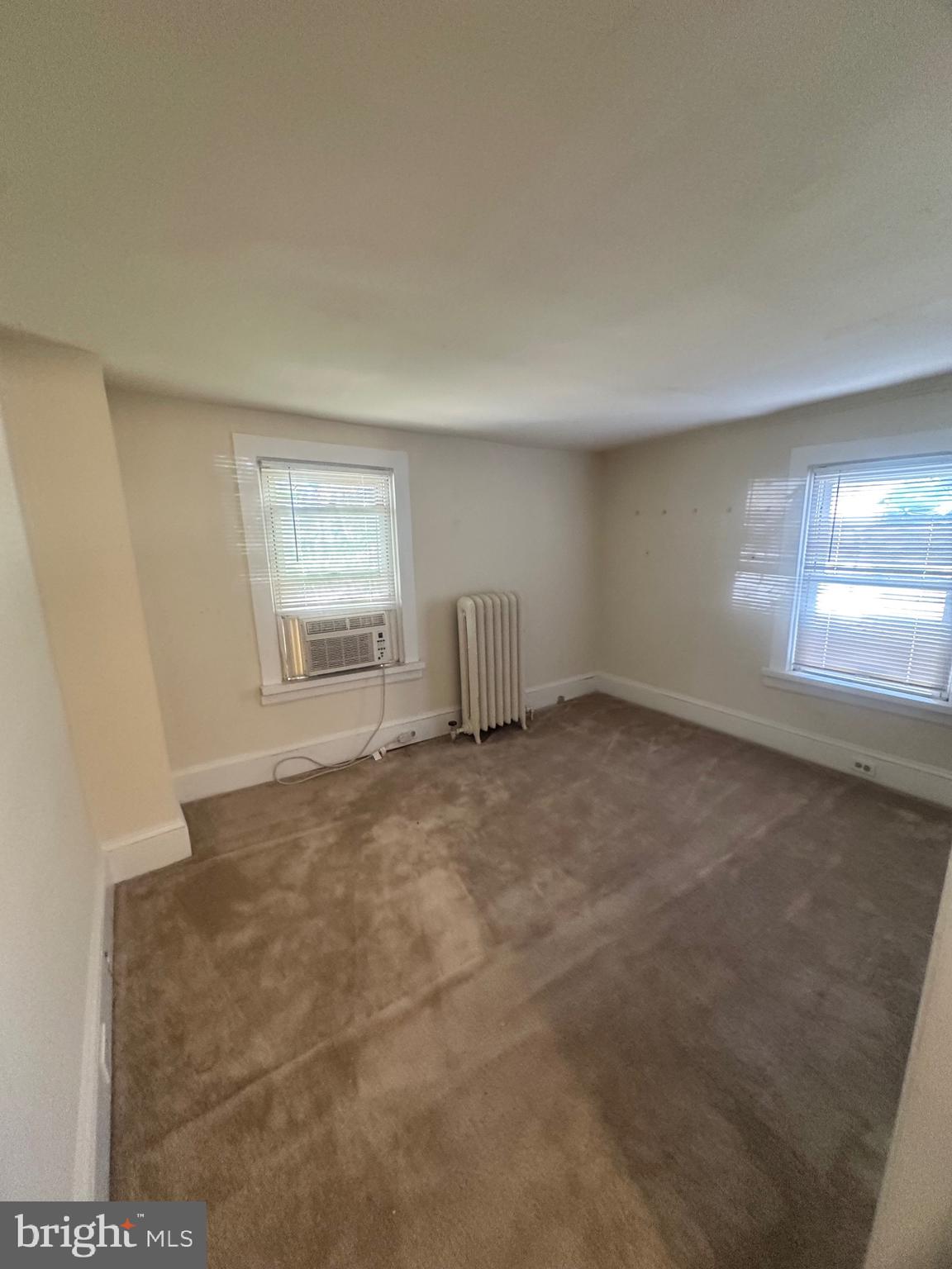 71 Sproul Road, Unit 3 Malvern, PA 19355 - Photo 3 of 11 an empty room with a fireplace and windows