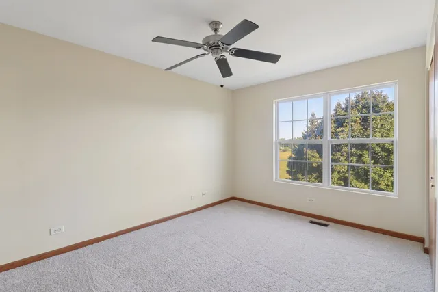 an empty room with a window and a fan