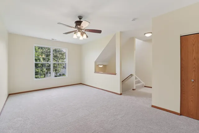 a view of a livingroom with a ceiling fan and window