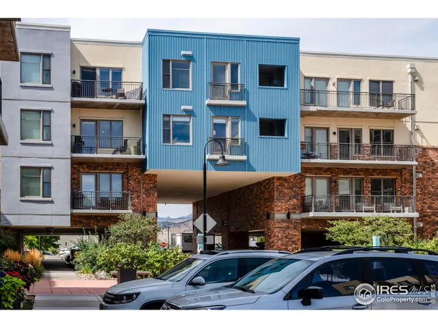 a front view of a multi story residential apartment building with yard and traffic signal