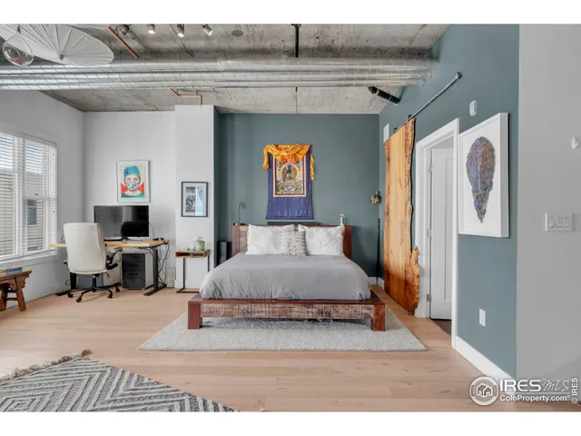 a bedroom with a bed and a painting on the wall