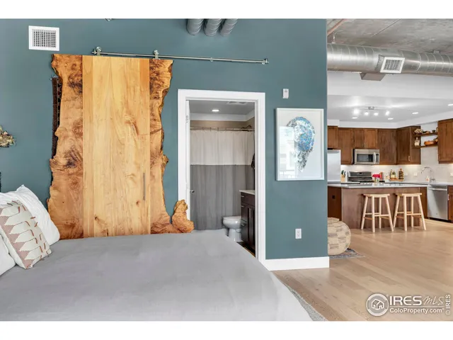 a bedroom with a bed and a view of kitchen