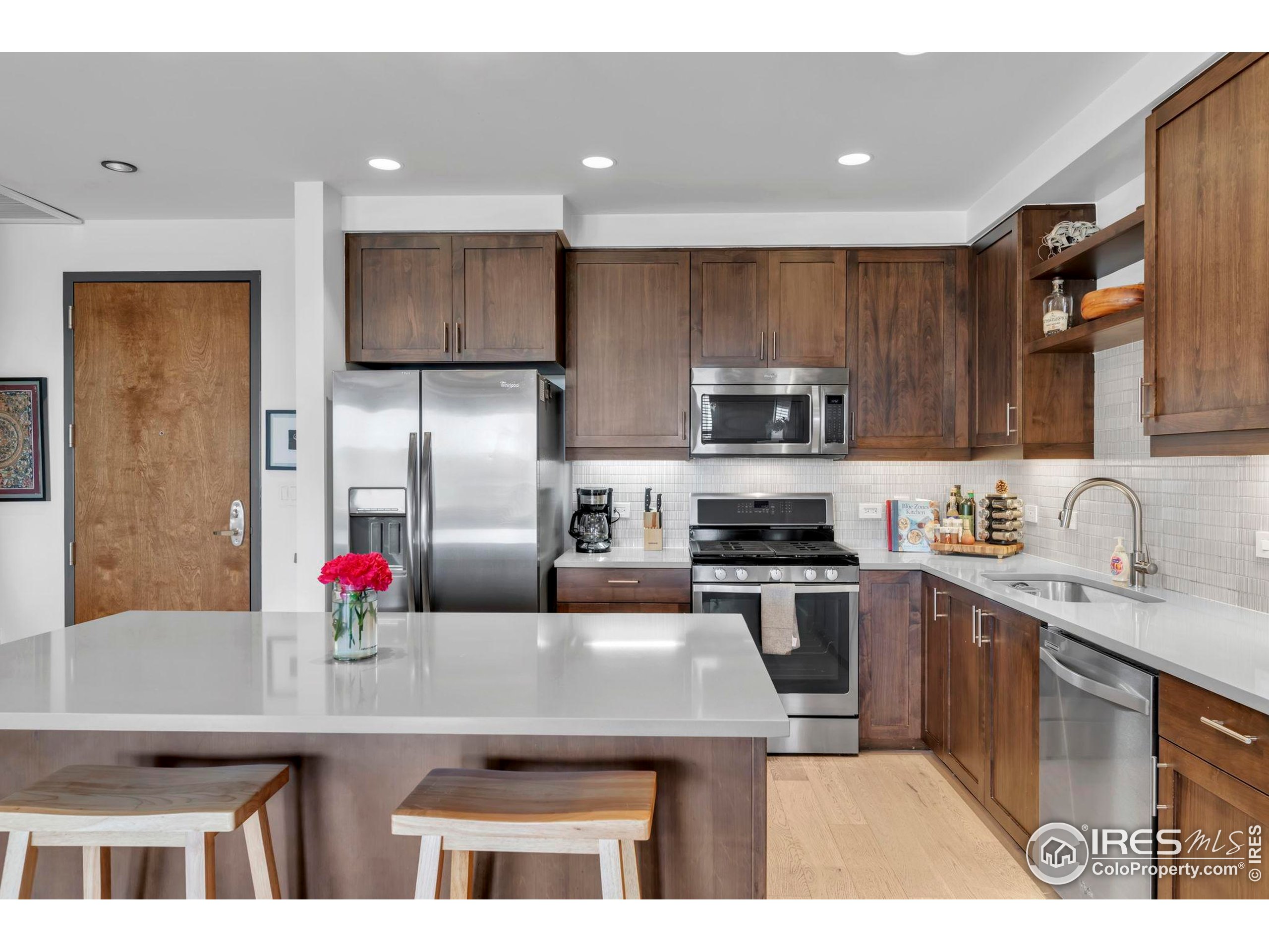 3301 Arapahoe Avenue, Unit 405 Boulder, CO 80303 - Photo 7 of 36 a kitchen with kitchen island a sink stainless steel appliances and cabinets