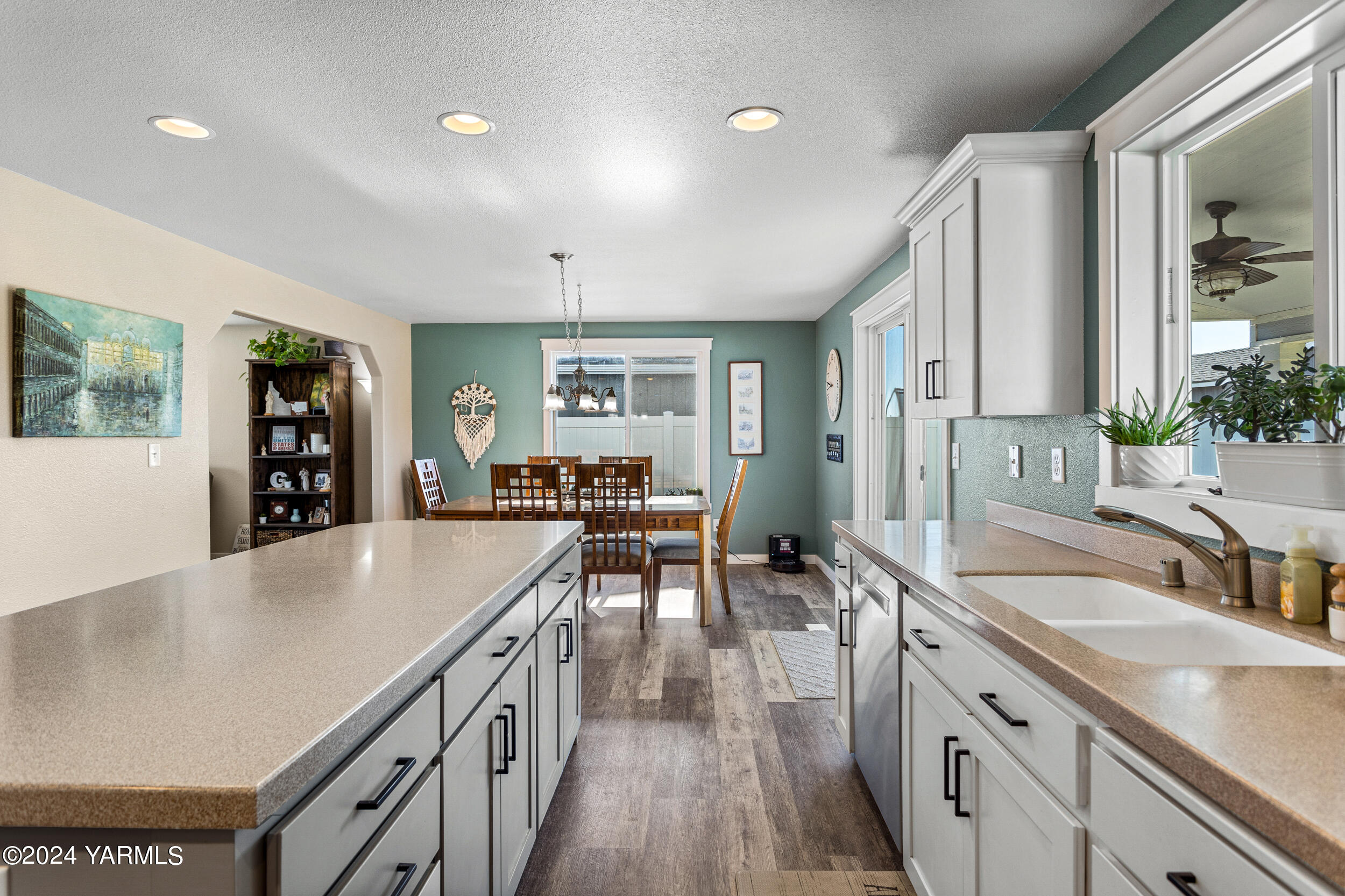 810 Millenium Avenue Moxee, WA 98936 - Photo 12 of 38 a large kitchen with kitchen island a large counter top space a sink a window and stainless steel appliances