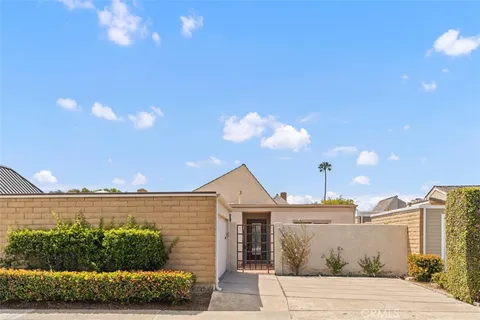 a front view of a house with a yard and potted plants