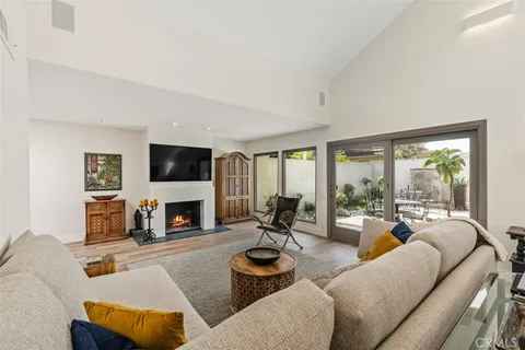 a living room with furniture fireplace and a large window