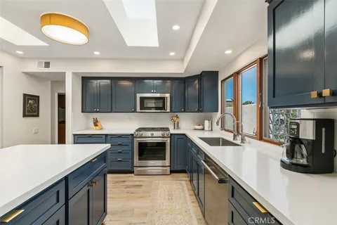 a kitchen with stainless steel appliances granite countertop a sink and stove top oven