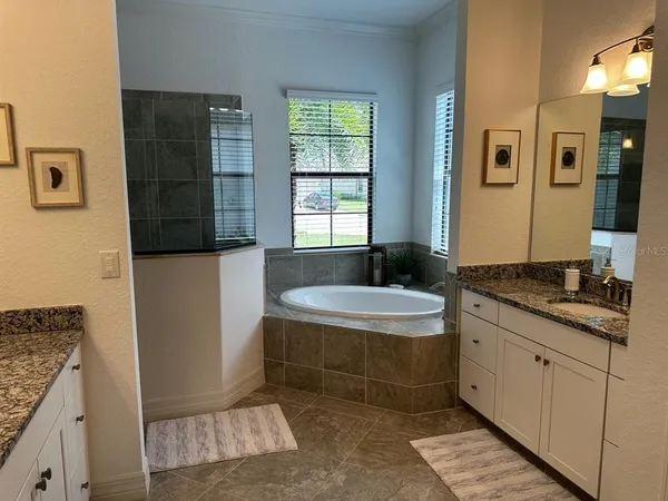 a spacious bathroom with a granite countertop sink a toilet a mirror and shower