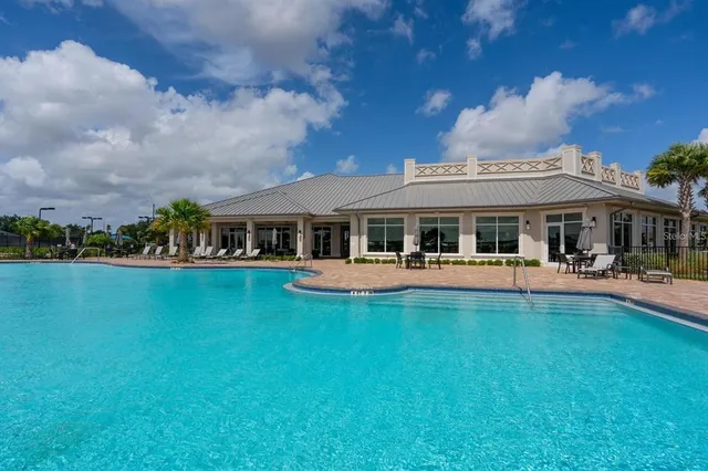 a view of house with swimming pool yard and outdoor seating