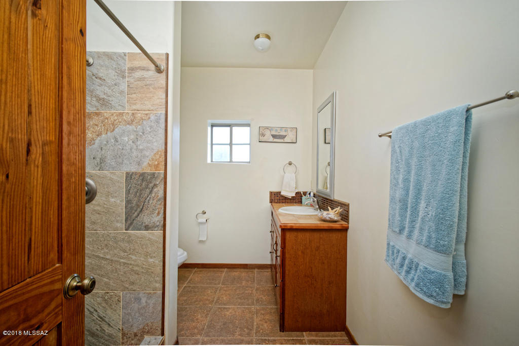 1721 Camino Jalisco Rio Rico, AZ 85648 - Photo 13 of 39 a bathroom with a granite countertop shower a mirror and a sink