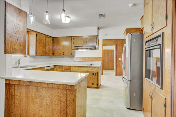 a view of a kitchen with a sink and a refrigerator