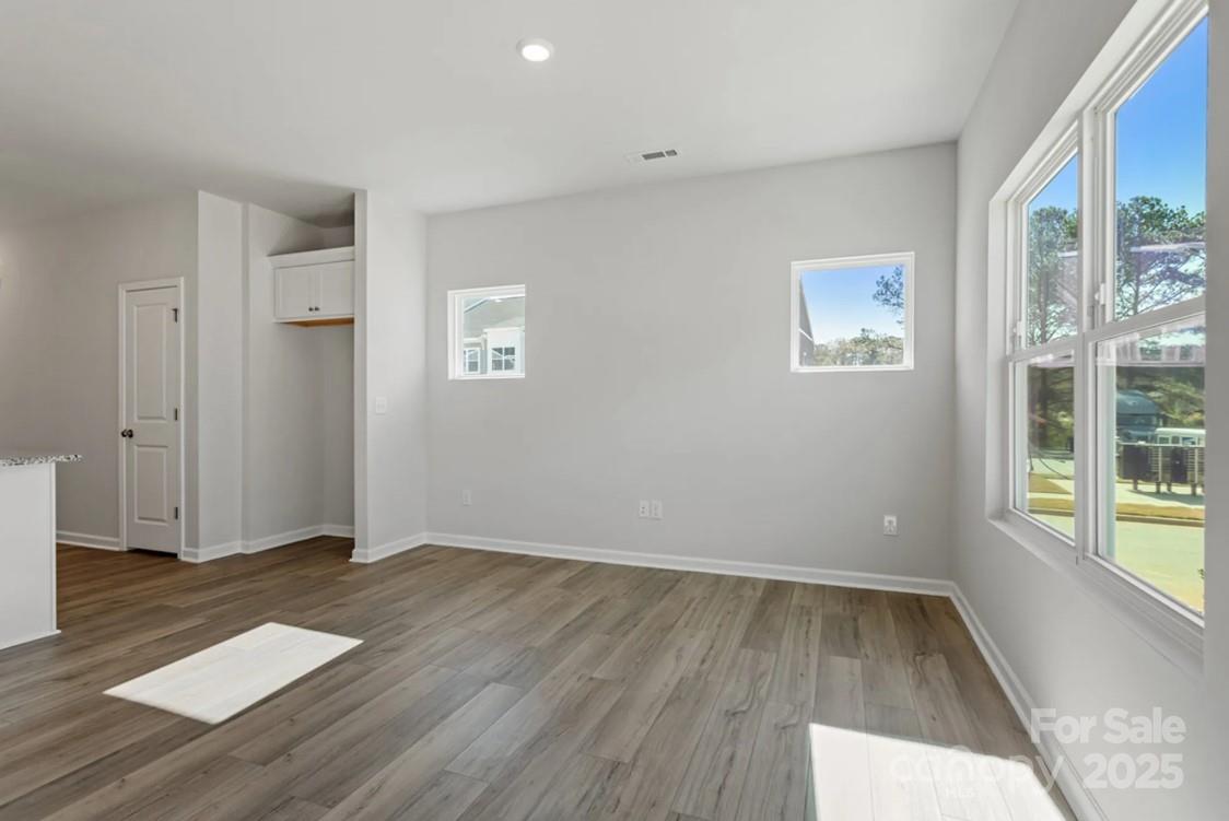 2712 Lehigh Road Charlotte, NC 28208 - Photo 5 of 7 an empty room with wooden floor and windows