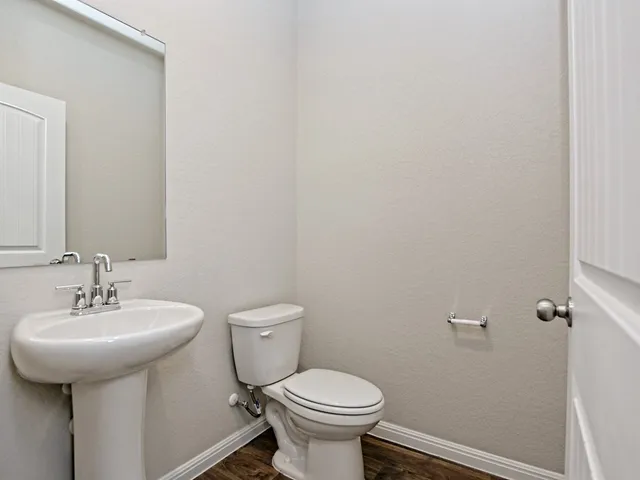 a view of an empty room with wooden floor and window
