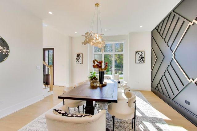 a kitchen with stainless steel appliances kitchen island a table and chairs in it
