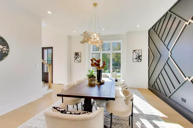 a kitchen with stainless steel appliances kitchen island a table and chairs in it