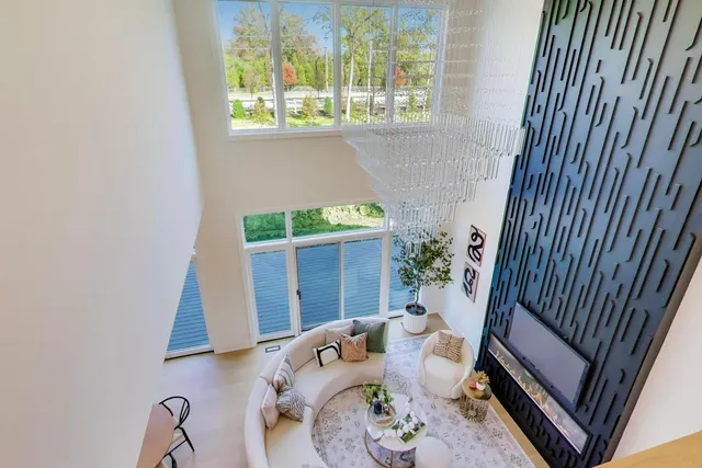 an empty room with windows and chandelier fan