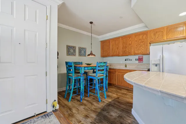 a kitchen filled with stainless steel appliances wooden floor dining table and chairs