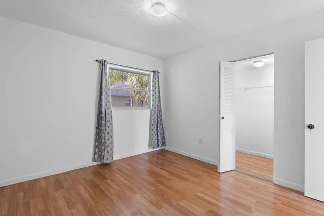 a view of empty room with wooden floor