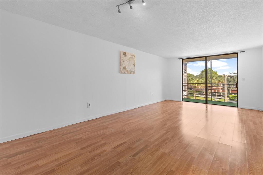 1830 Southwest 81st Avenue, Unit 4317 North Lauderdale, FL 33068 - Photo 12 of 22 a view of an empty room with wooden floor and a window