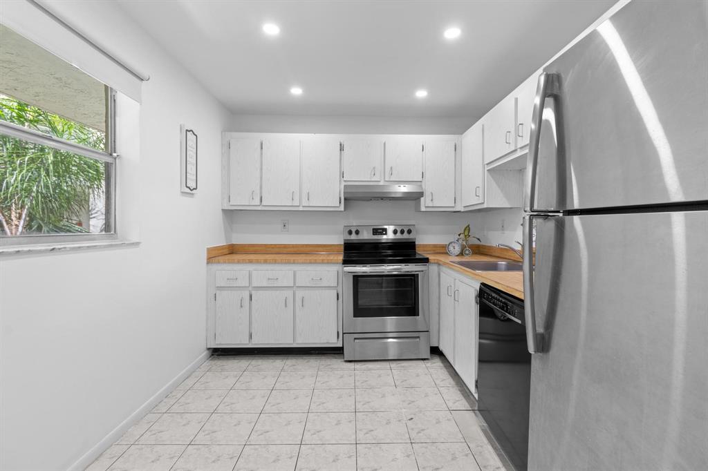 1830 Southwest 81st Avenue, Unit 4317 North Lauderdale, FL 33068 - Photo 4 of 22 a kitchen with white cabinets and white stainless steel appliances