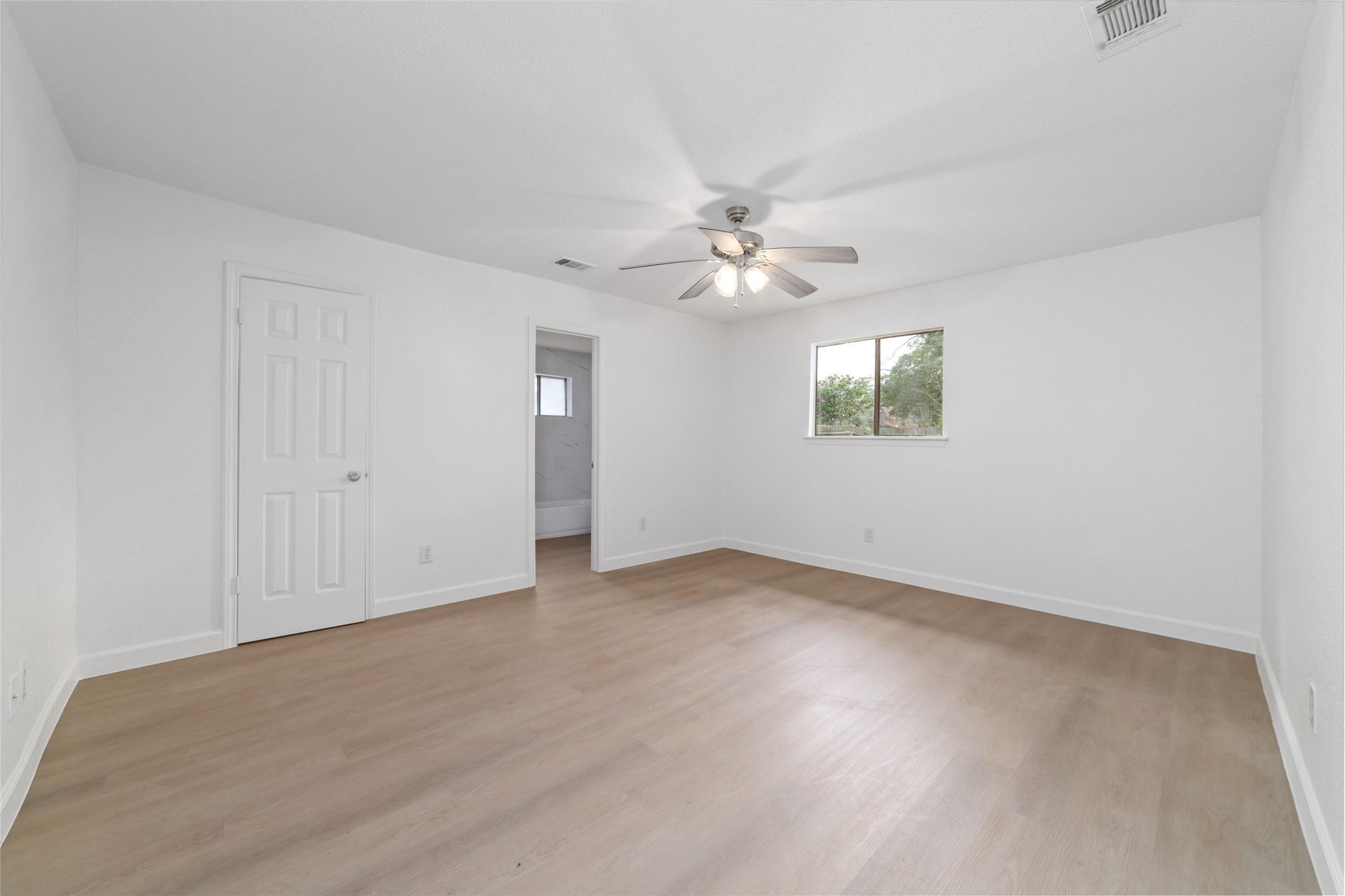 5023 Monteith Drive Spring, TX 77373 - Photo 11 of 20 Generous bedroom with a ceiling fan and large window that fills the room with natural light, offering a comfortable and relaxing retreat with easy access to the adjoining bath.